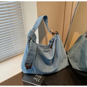 Λεπτομέρεια μπλε τσάντας denim με καφέ δερμάτινη επένδυση και δεμένο λουράκι ώμου