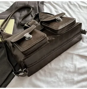 Detail of dark brown leather tote bag with front flap pockets and silver metal buckles