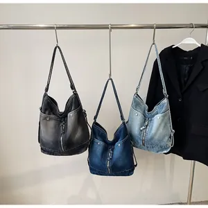 Λεπτομερής προβολή μεγάλων vintage τσαντών denim σε μαύρο-γκρι, σκούρο μπλε και γαλάζιο χρώμα