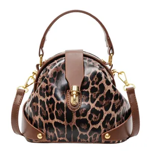 Modern leopard print shell handbag with golden twist lock and brown leather straps