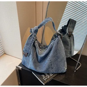Λεπτομέρεια τσάντας hobo denim με λουρί με κόμπο και δερμάτινες λεπτομέρειες