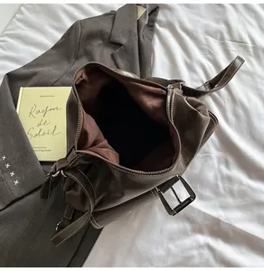 Detailed view of dark brown faux leather bag with white contrast stitching and spacious interior