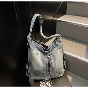 Λεπτομερής όψη της ρετρό τζιν τσάντας με μεταλλικά πριτσίνια και μπροστινή τσέπη με φερμουάρ