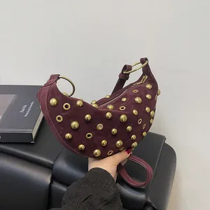 Punk style burgundy suede crescent underarm bag with gold rivets and eyelet studs