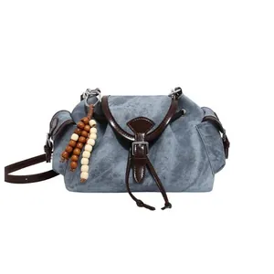 Vintage blue denim shoulder bucket bag with brown leather trim and beaded ornament