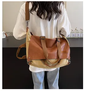 Model wearing a vintage khaki canvas and brown leather tote bag with a wide shoulder strap