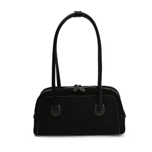 Black faux suede baguette shoulder bag with contrast white stitching and leather handles