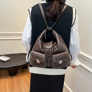 Vintage brown leather backpack with contrast stitching and metallic buckles