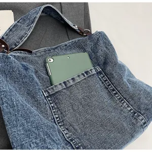 Λεπτομέρεια εξωτερικής τσέπης τσάντας denim με tablet για καθημερινή μετακίνηση