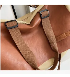 Close-up of durable stitching and canvas texture on a vintage brown leather tote bag