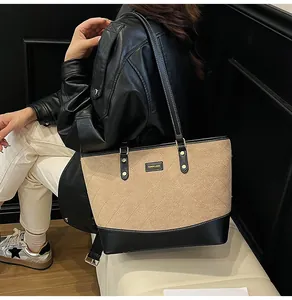 Λεπτομέρεια δίχρωμης καπιτονέ τσάντας tote με λογότυπο και ραφές αντίθεσης στον ιμάντα