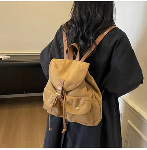Vue détaillée d'un sac à dos vintage en toile avec lanières en cuir sur un mannequin