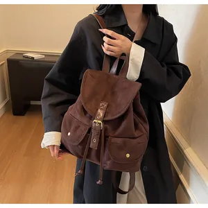 Détails du sac à dos vintage en daim marron foncé avec boucles dorées et cordons