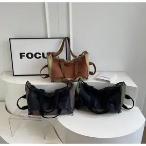 Three vintage canvas and leather tote bags in khaki, brown, and green colors