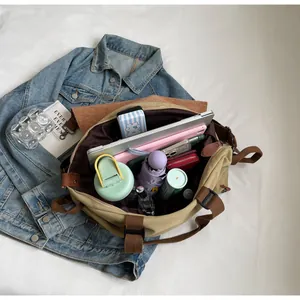 Detailed top view of a khaki canvas tote bag showing large capacity for laptop and daily items