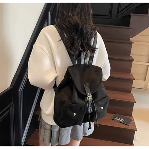 Vue arrière d'un mannequin portant un sac à dos noir à cordon avec détails dorés en escalier