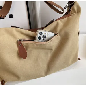 Macro shot of khaki canvas tote bag front zipper pocket with phone for size reference