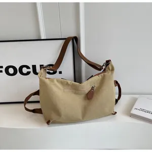 Detailed close-up of khaki canvas tote bag featuring premium leather zipper pull and strap