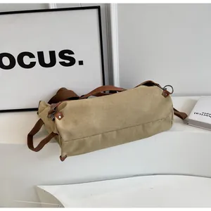 Detail of khaki canvas Boston bag with brown leather trim and metallic D-ring buckle