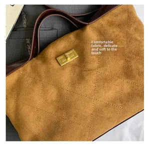 Detailed close-up of quilted suede shoulder bag with gold metal buckle and leather strap