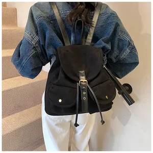 Detail of vintage black suede backpack with drawstring closure and gold metal hardware