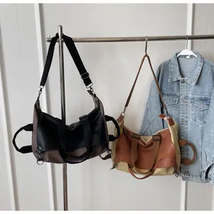 Detail of vintage canvas tote bags with PU leather trim and wide adjustable strap