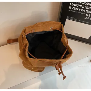 Détail d'un sac à dos vintage en daim marron avec cordon de serrage et œillets dorés