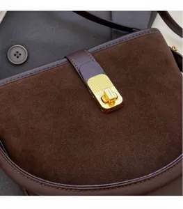Close-up of golden vertical stripe twist lock on coffee frosted bucket bag detail