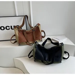 Detail of khaki and green canvas tote bags with premium leather trim and metal hardware