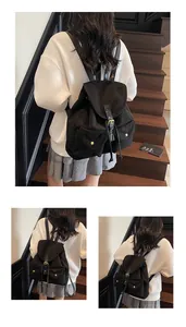 Détail d'un sac à dos en toile noire avec boucles en cuir et poches latérales pratiques