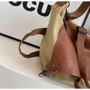 Detail view of khaki canvas and brown leather tote with adjustable shoulder strap