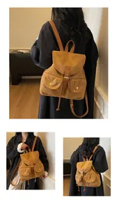 Détail d'un sac à dos vintage en daim marron avec boucles en cuir et poches frontales