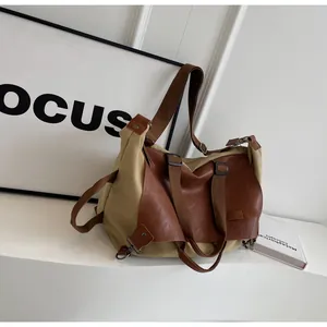 Detail of vintage khaki canvas and brown leather tote with metal hooks and strap
