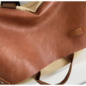 Detail of vintage brown leather and beige canvas stitching with metal rivet reinforcement