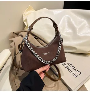 Dettaglio della borsa hobo in camoscio marrone con catena d'argento e testo logo