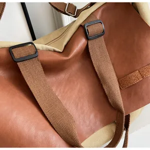 Detail of vintage tote bag showing brown PU leather and beige canvas with metal ring