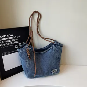 Stylish denim tote bag with brown rope handles and metal detail for casual daily use