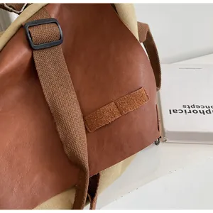 Detail of leather and canvas stitching with adjustable strap on a vintage tote bag