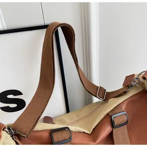 Detail of adjustable woven strap and metal hooks on brown vintage tote travel bag