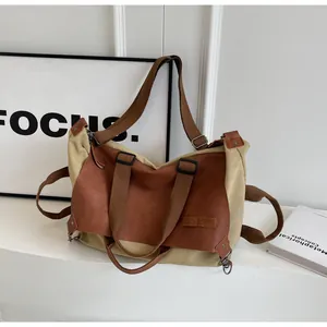Detail of khaki canvas and brown faux leather patchwork tote bag with adjustable strap