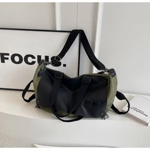 Detail of army green canvas tote with black leather trim and adjustable shoulder strap
