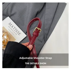 Detail of red synthetic leather adjustable shoulder strap with golden pin buckle