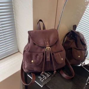 Sac à dos vintage en daim marron foncé avec fermeture à cordon et boucles sur le rabat