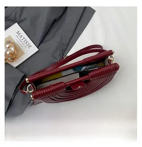 Interior view showing the large capacity of the woven burgundy crossbody bag