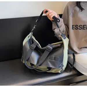 Detail of army green canvas and black leather stitching on a large tote bag with strap