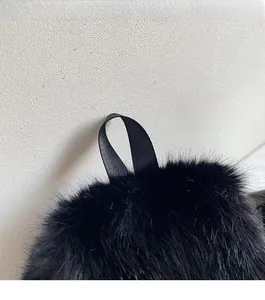 Close-up of black faux fur backpack featuring durable silk texture ribbon handles