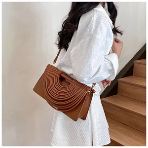 Close-up of brown woven texture and layered semi-circular leather design on a handbag