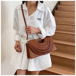 Detail view of brown rectangular handbag with unique semi-circular pleated texture design