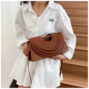 Detailed view of brown woven texture on a fashion handbag with concentric pleat design