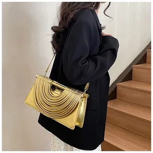 Detailed view of golden woven evening clutch with metallic arc pattern and chain strap